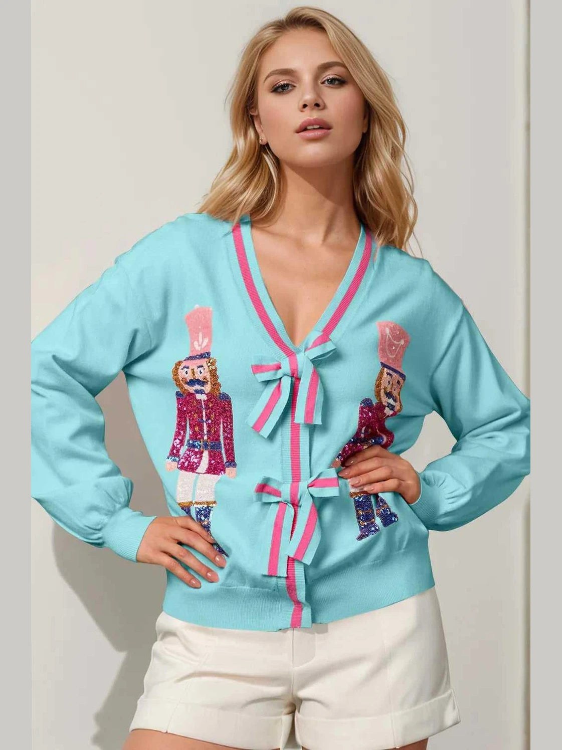 Woman wearing a light blue cardigan with decorative elements on a white background