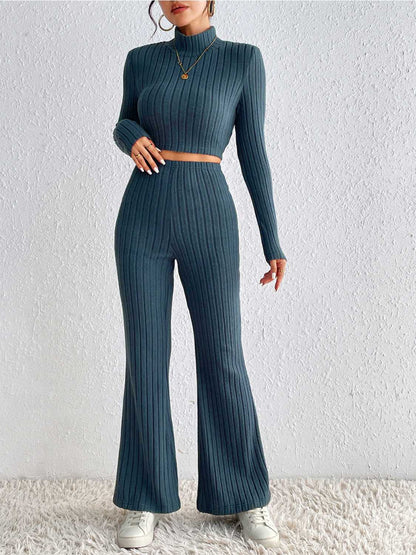 Person wearing a teal ribbed knit two-piece set against a white background
