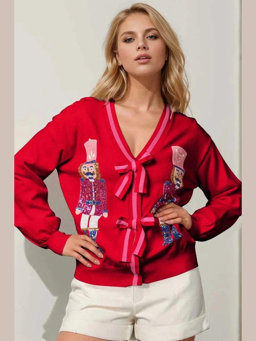 Woman wearing a red sweater with nutcracker design and white shorts on a plain background